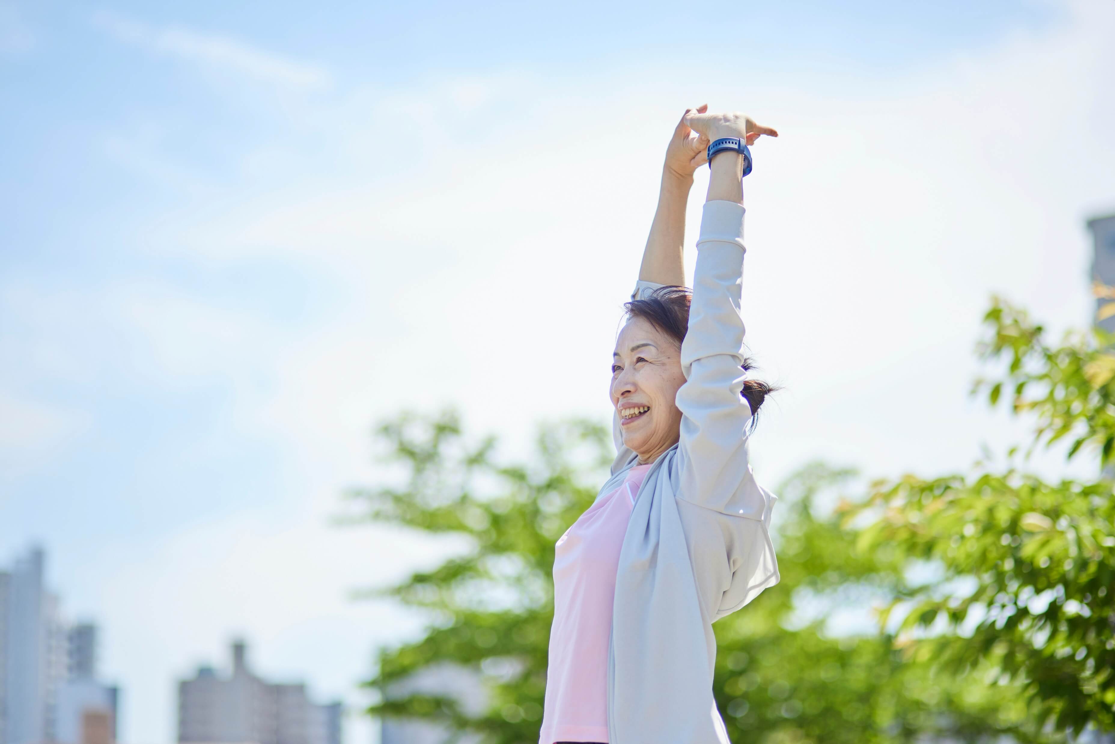 屋外で背伸びする女性